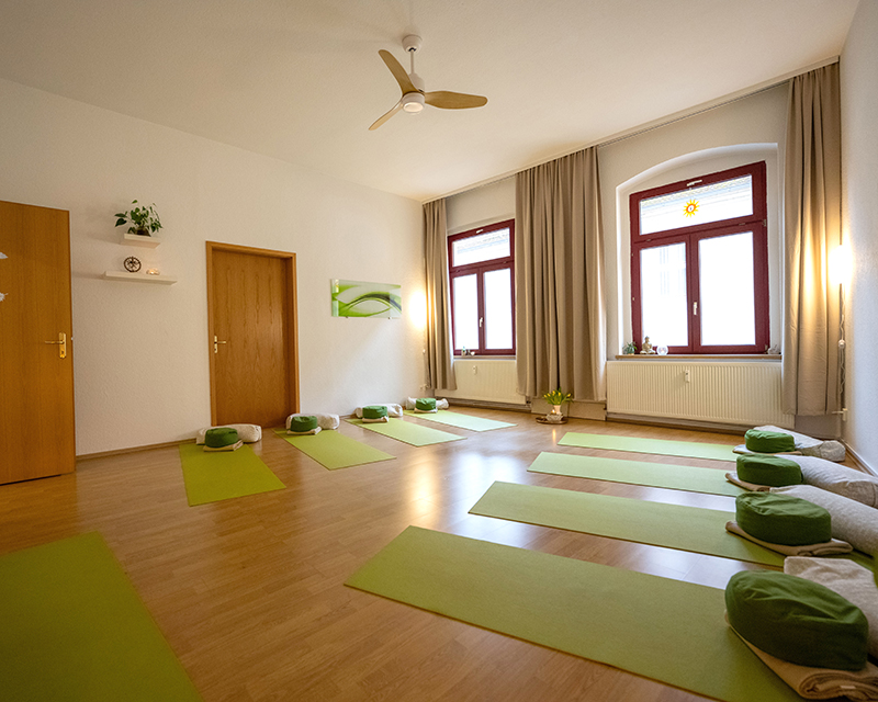 Großer Raum mit Yogamatten und Garderobe